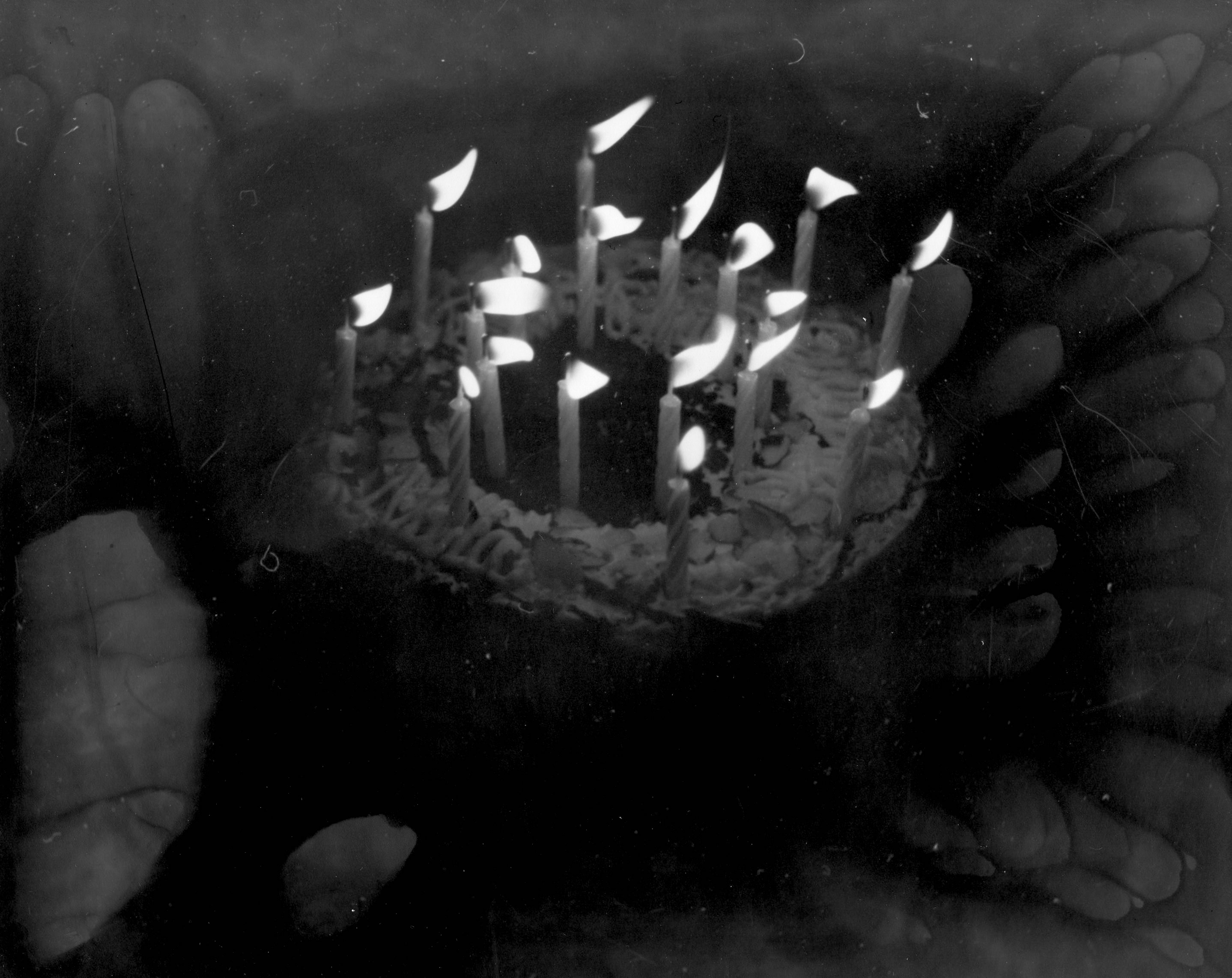 black and white photograph of a birthday cake with candles